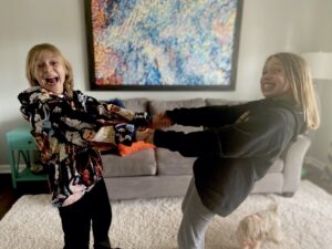 boy and girl playing tug of war falling away