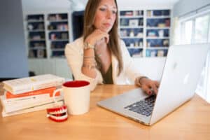 woman at computer with chattering teeth on desk