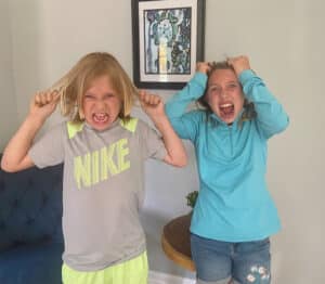 two children pulling at their hair
